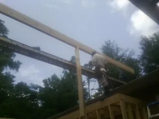 Carpenter setting a ridge beam over a new addition frame — Ice Dam Removal by Roofing Brothers in Pine Prairie