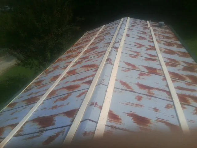 Rusted metal roof panels with new wood purlins before replacement — Storm Damage Roof Repair in Pine Prairie by Roofing Brothers